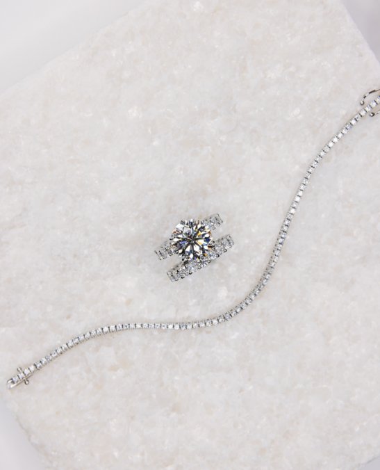 Custom white gold diamond engagement ring, wedding band, and tennis bracelet by NYC jeweler Clarity by Claire