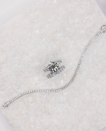 Custom white gold diamond engagement ring, wedding band, and tennis bracelet by NYC jeweler Clarity by Claire